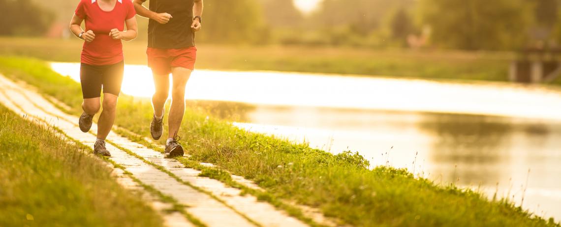 Twee mensen die hardlopen langs het water
