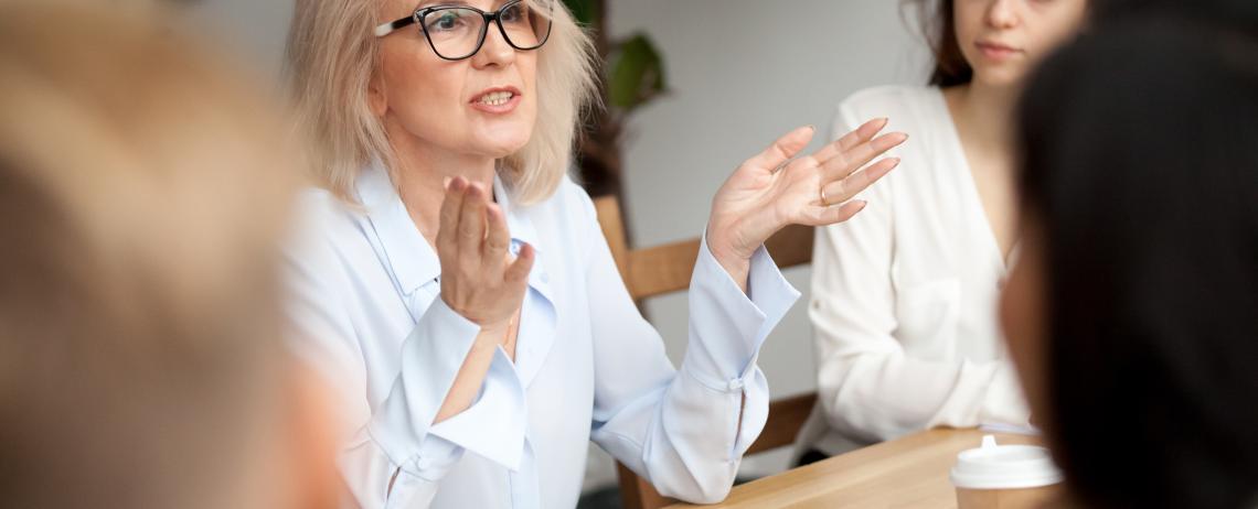 Vrouw met bril in overleg met andere mensen