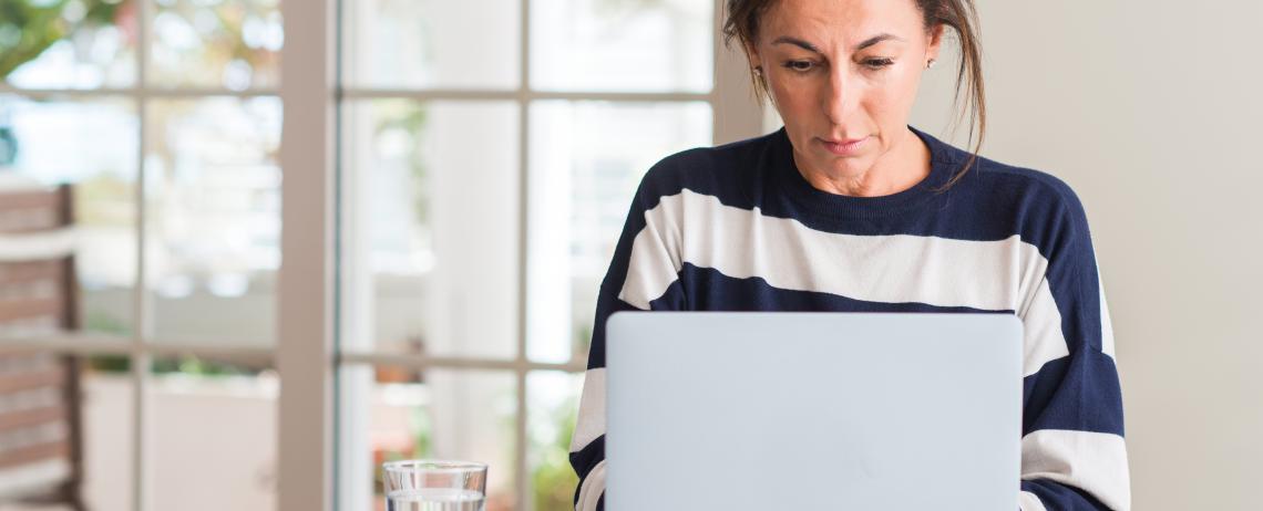 Vrouw aan het werk op laptop bij raam